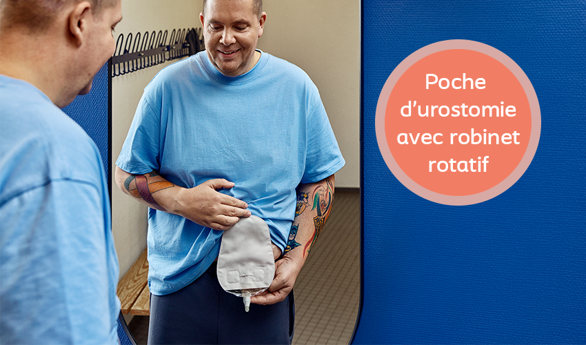 Un homme en t-shirt bleu, portant une poche de stomie sur le ventre, dans une cabine d'essayage